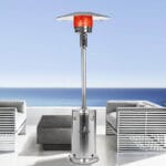 Silver Verona heater outside in front of sofas with beach in the distance